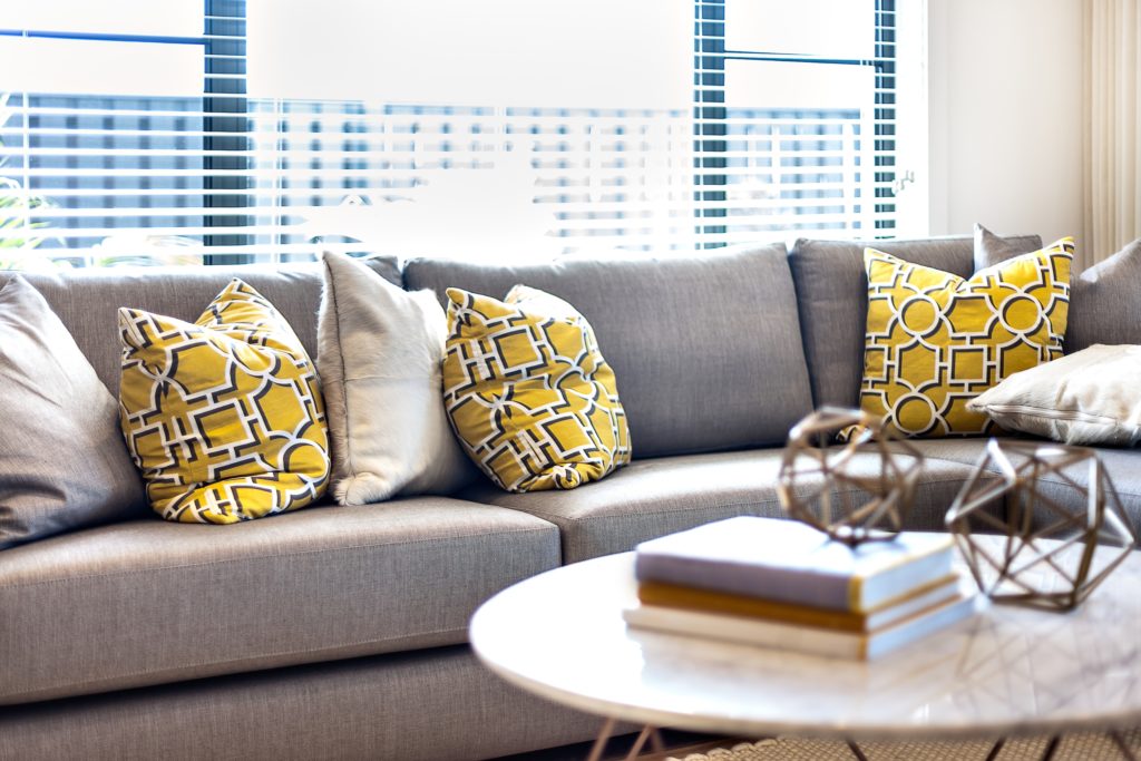 Large Gray Corner Couch with Yellow and Gray Throw Pillows