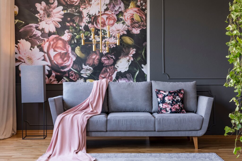 Retro Gray Couch with Powder Pink Blanket Enhanced by Stunning Floral Wallpaper